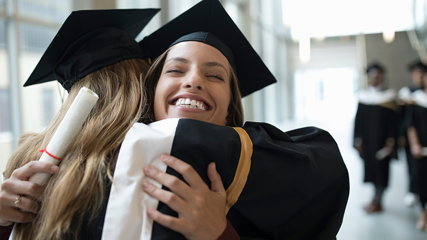 Two Female Friends Embracing after Graduation