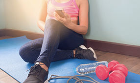 Woman in workout clothes sitting on a yoga mat