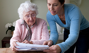 Elderly Woman Being Assisted with Paperwork