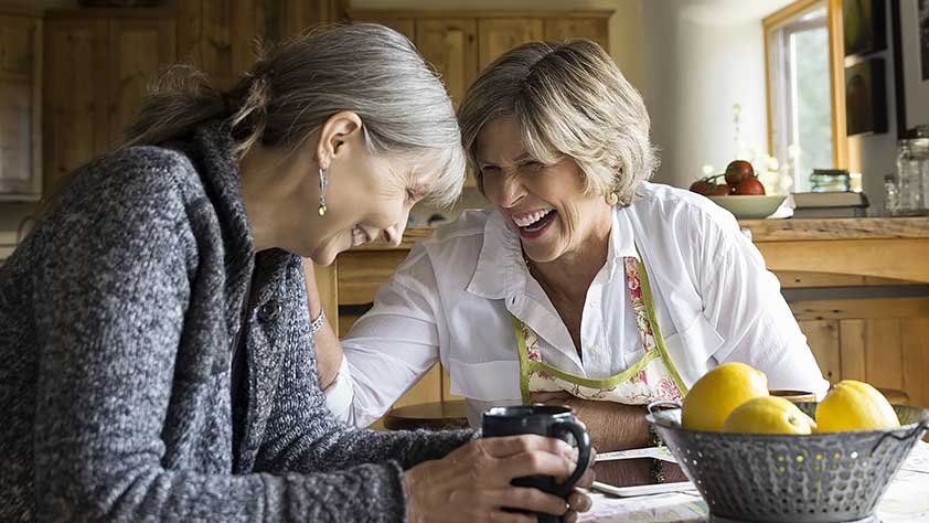 The Importance of Life Insurance Over Age 50 - Senior Women Laughing and Drinking Coffee at Dining Table