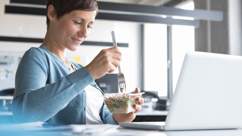 Woman eating lunch in front of her laptop