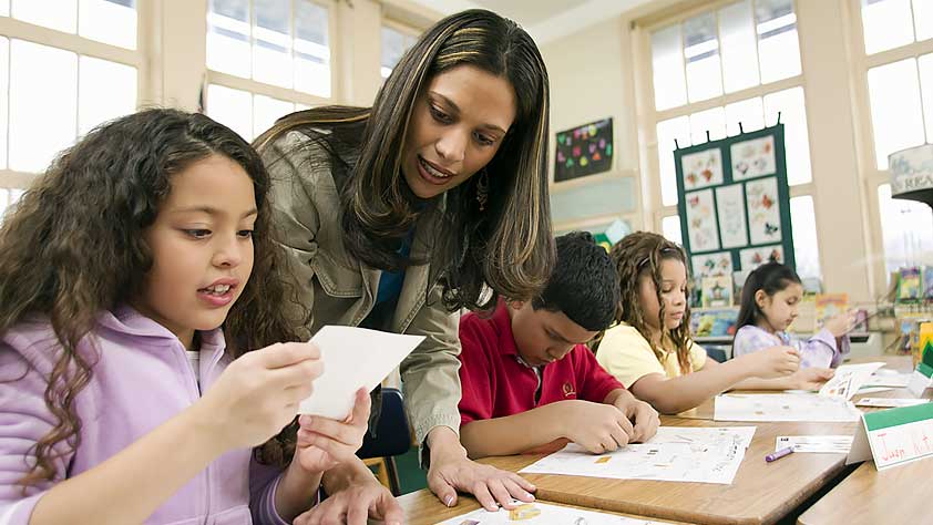Hispanic Schoolteacher Helping Students