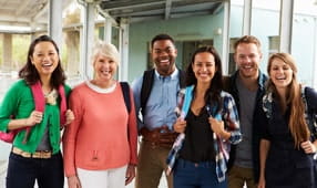 A group of cheerful teachers hanging out in school corridor