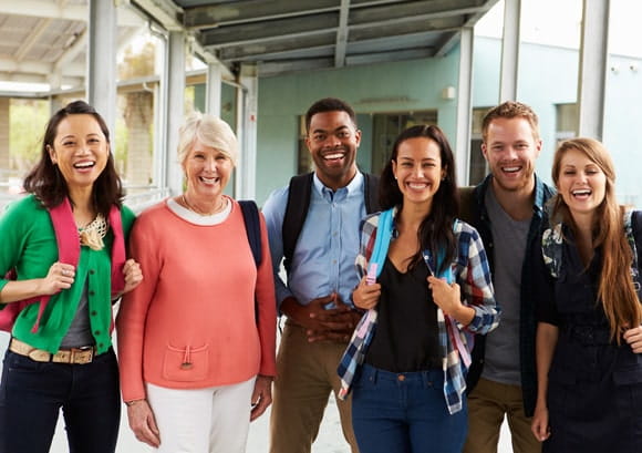 A group of cheerful teachers hanging out in school corridor