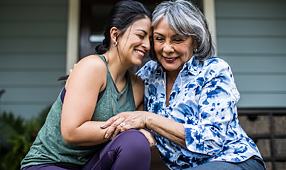 Senior Woman and Adult Daughter Hugging and Laughing on Porch