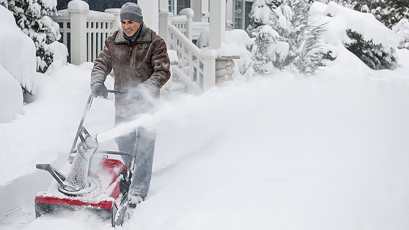 Why You Might Need Extra Cash This Winter - Man Clearing Driveway with a Red Snowblower
