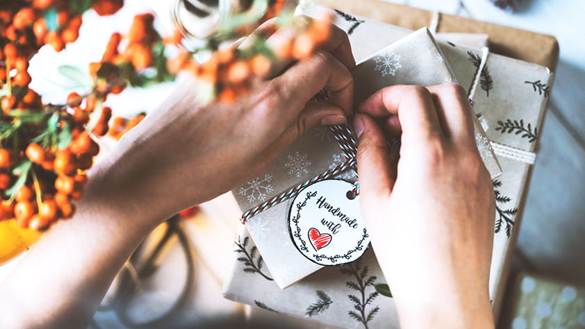 Close-up of a woman's hands wrapping holiday gifts