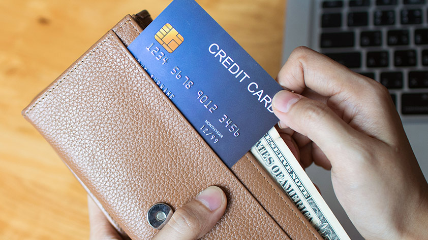 Close Up of Credit Card Being Placed into Wallet