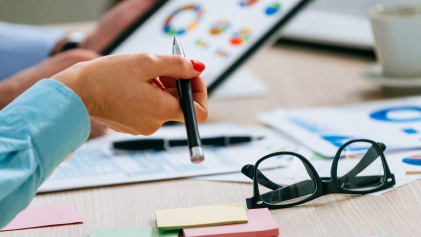 Close-up of hands holding a tablet displaying financial charts