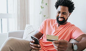 Man Using Credit Card and Buying Online on Mobile Phone