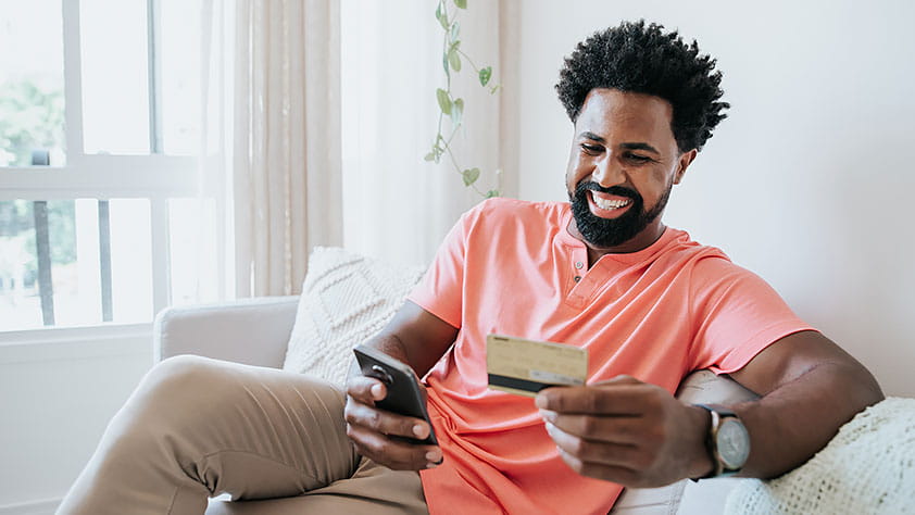 Man Using Credit Card and Buying Online on Mobile Phone