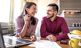 Husband and Wife Smiling While Reviewing Financial Information