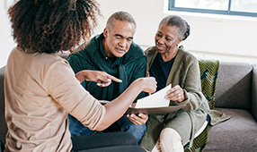 Elderly African American Couple Being Instructed on Paperwork