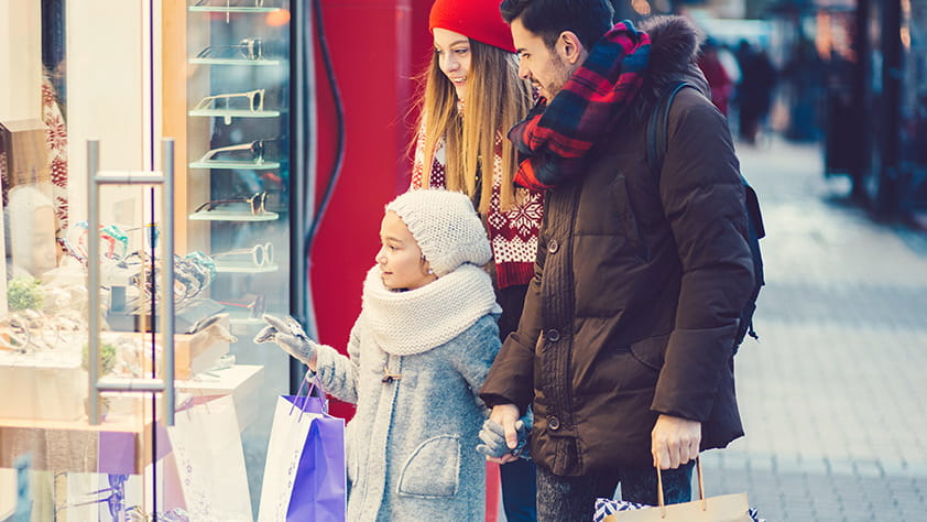 Young Girl in Awe Looking in Storefront Window with Parents