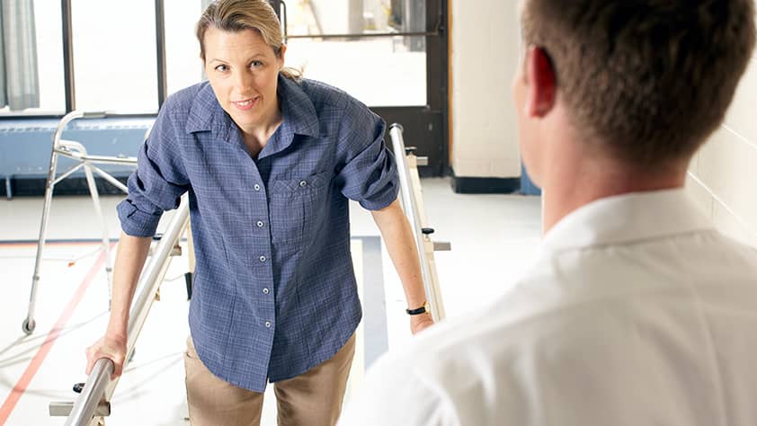 Young Woman Doing Physical Therapy on Balance Bars