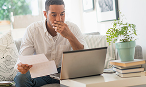 Concerned African American Male Reviewing Financial Statement