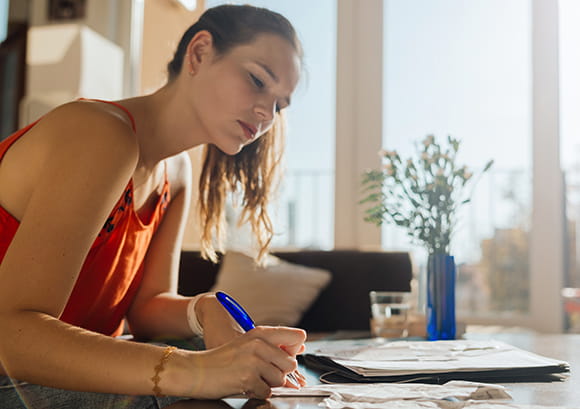 Close Up of Female Writing on Coffee Table