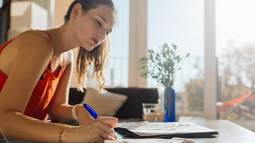 Close Up of Female Writing on Coffee Table