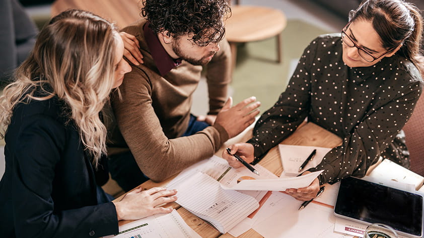 Female Financial Planner Assisting Couple with Finances