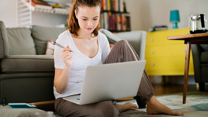 Woman Sitting on Floor with Laptop on Lap