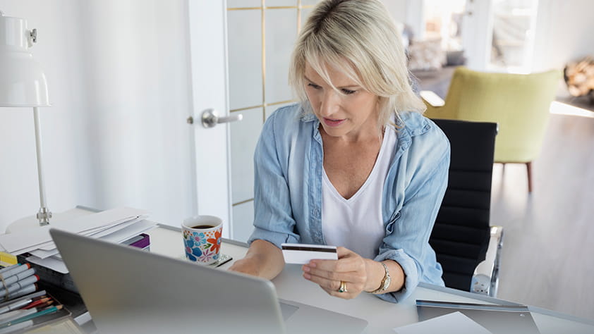 Woman at Home Office Desk Adding Credit Card Payment Online