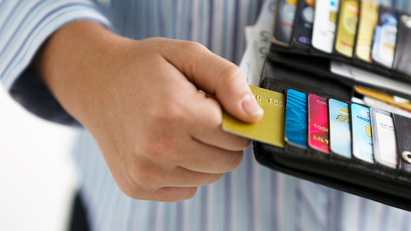 Close-up of a woman's hand pulling a credit card out of her wallet