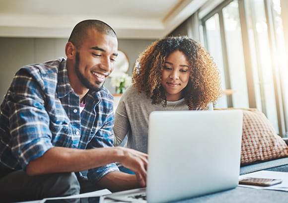 African American Couple Smiling Reviewing Laptop Screen
