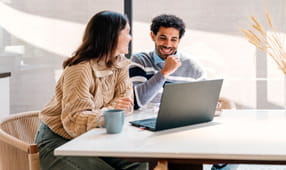 Young couple confidently accounting their finances at home on a laptop computer