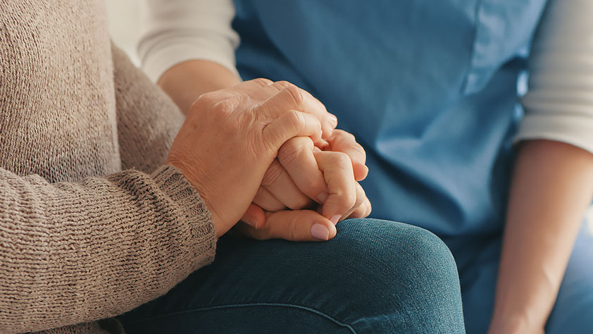 A Nurse Holds a Woman’s Hands to Provide Comfort