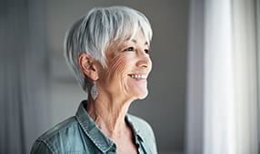 Senior Woman Smiling Staring Out Window