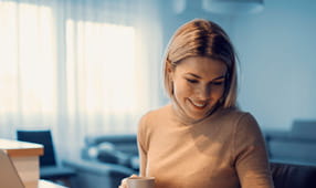 A happy NEA educator doing household budget in her cozy home