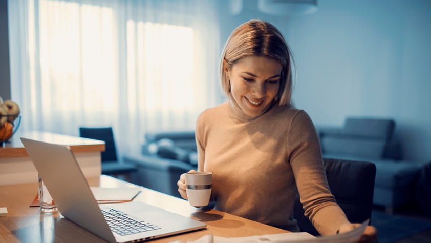 A happy NEA educator doing household budget in her cozy home