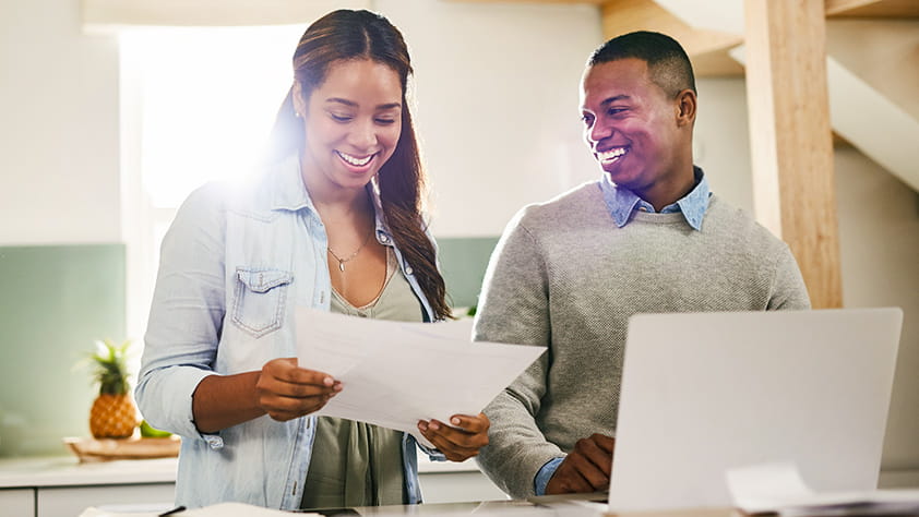 Couple planning their budget together on a laptop at home