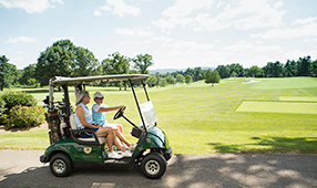 Women Driving Golf Cart on Course
