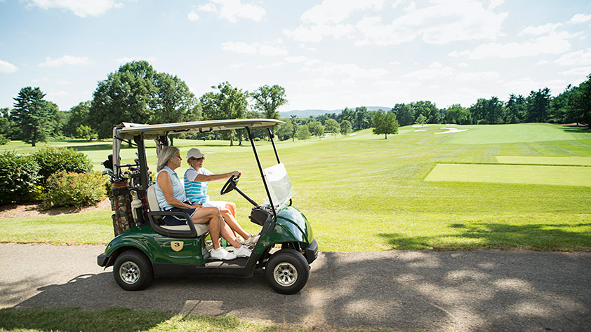 Women Driving Golf Cart on Course