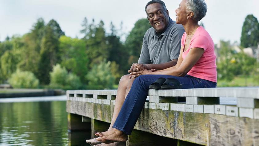 Retired African American Couple Enjoying Time Relaxing on Dock