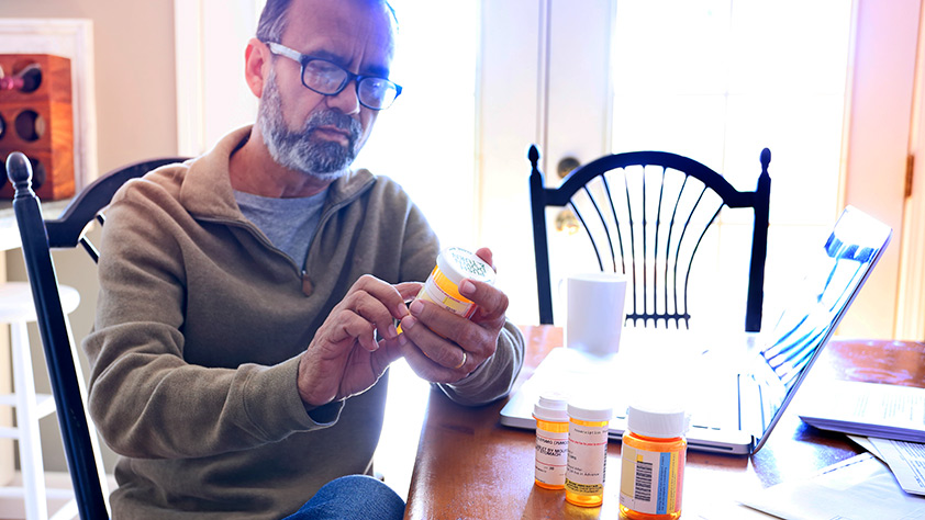 Older man looking at a prescription bottle