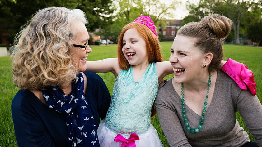 Three generations of women sitting in a park