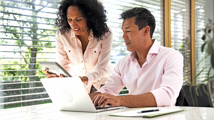 Couple working at home on their laptop and digital tablet