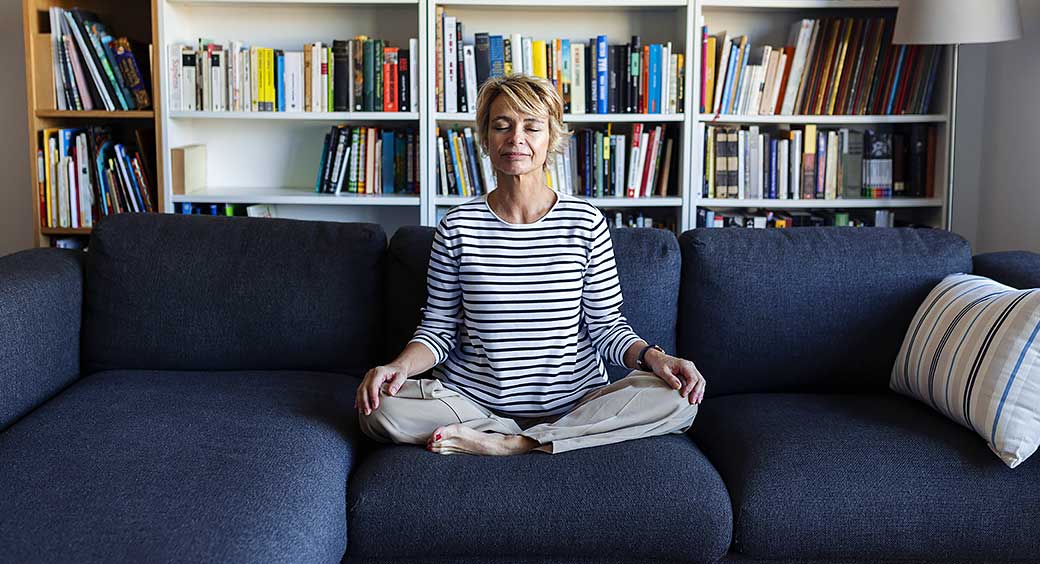 Woman Sitting on a Couch Meditating for Her New Year’s Resolution to Care for Her Mental Wellness