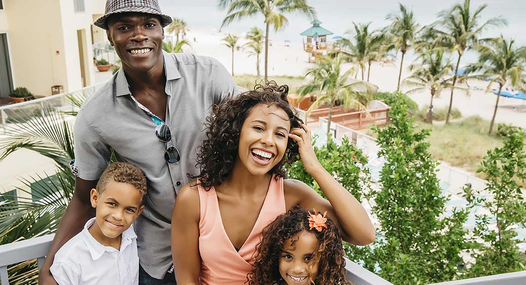 Young Family Vacations at a Resort Near a Beach and Palm Trees