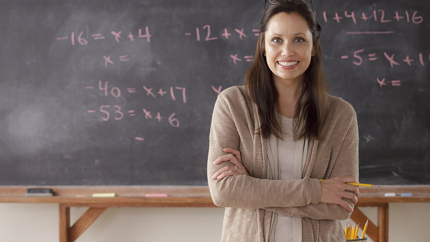 Portrait of a Teacher in Front of a Blackboard - Save a Bundle with Your NEA Member Benefits Teacher Discounts