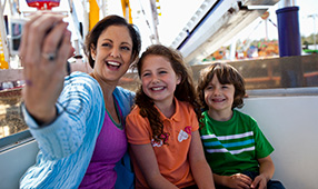 Mom Taking Selfie of Herself and Kids on Amusement Park Ride