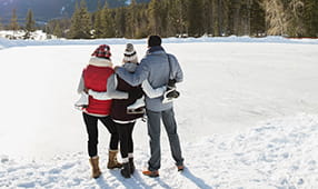 Three Friends Arm in Arm Looking at Mountains in the Winter Snow