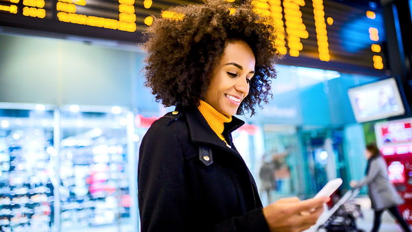 Practical Tips for Traveling Safely - Woman Using a Mobile Phone at the Airport