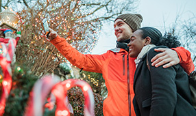 Couple Taking a Selfie in Front of a Holiday Lights Display