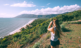Woman Looking Over Ocean View with Binoculars