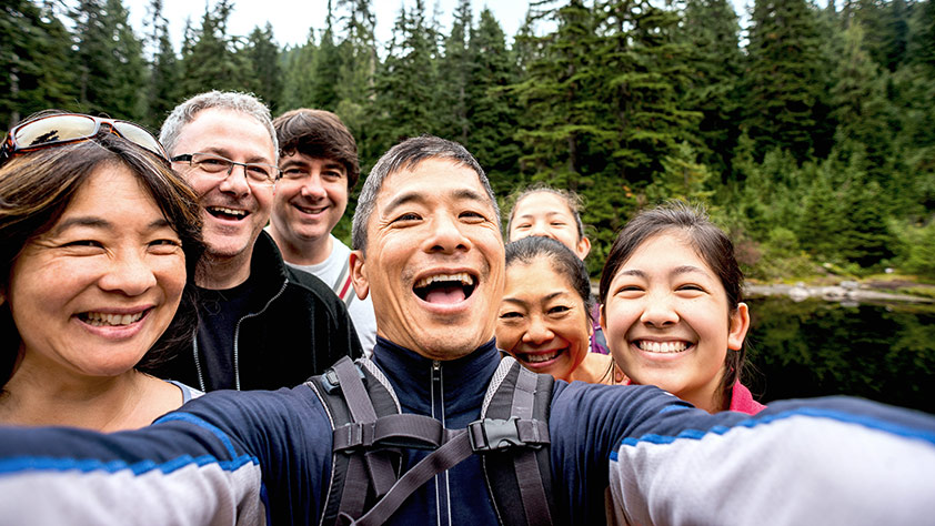 Extended family taking a selfie while hiking in the woods
