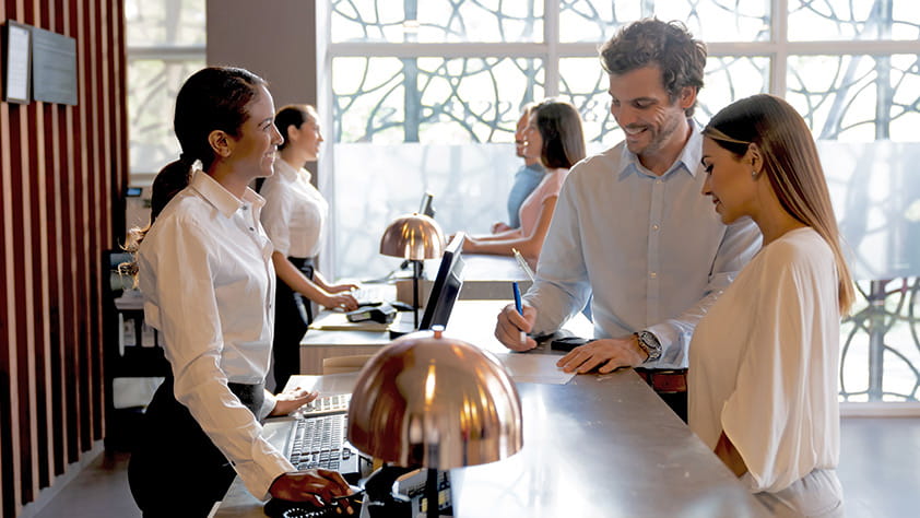 Couple checking in at a hotel front desk