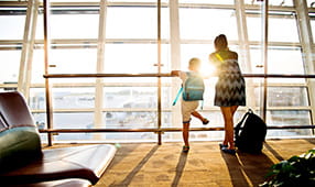 Mom and Son Looking Out Airport Terminal Window